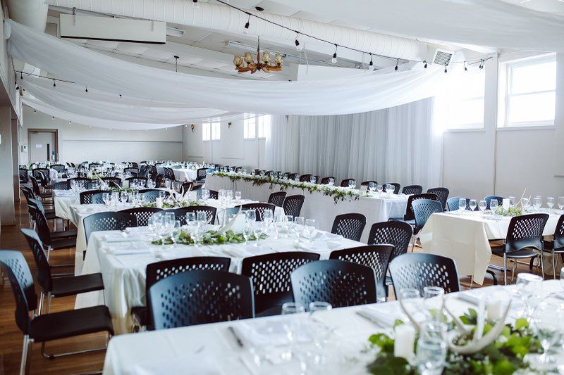 Wedding reception table set up - white tables clothes, white draping from ceiling